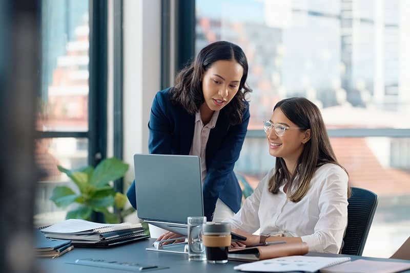 two women discussing what is on a computer screen