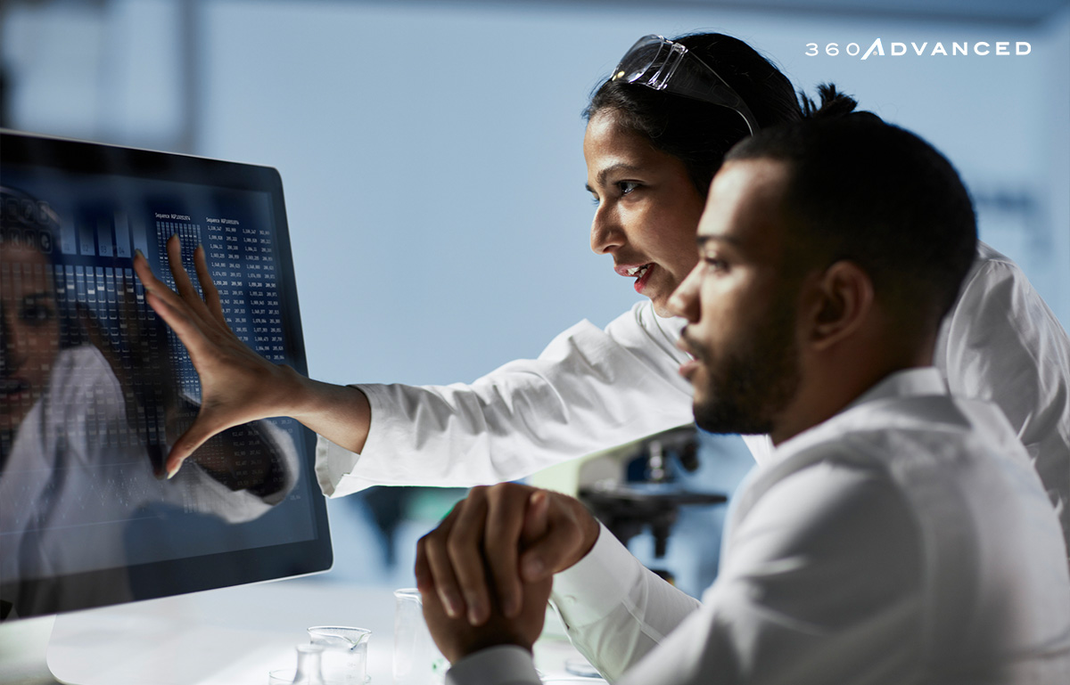 Medical colleagues working in front of a large monitor.