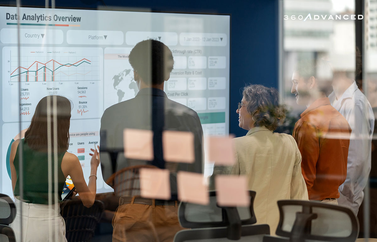 Diverse business development team brainstorming new products and services using a digital display during a business meeting