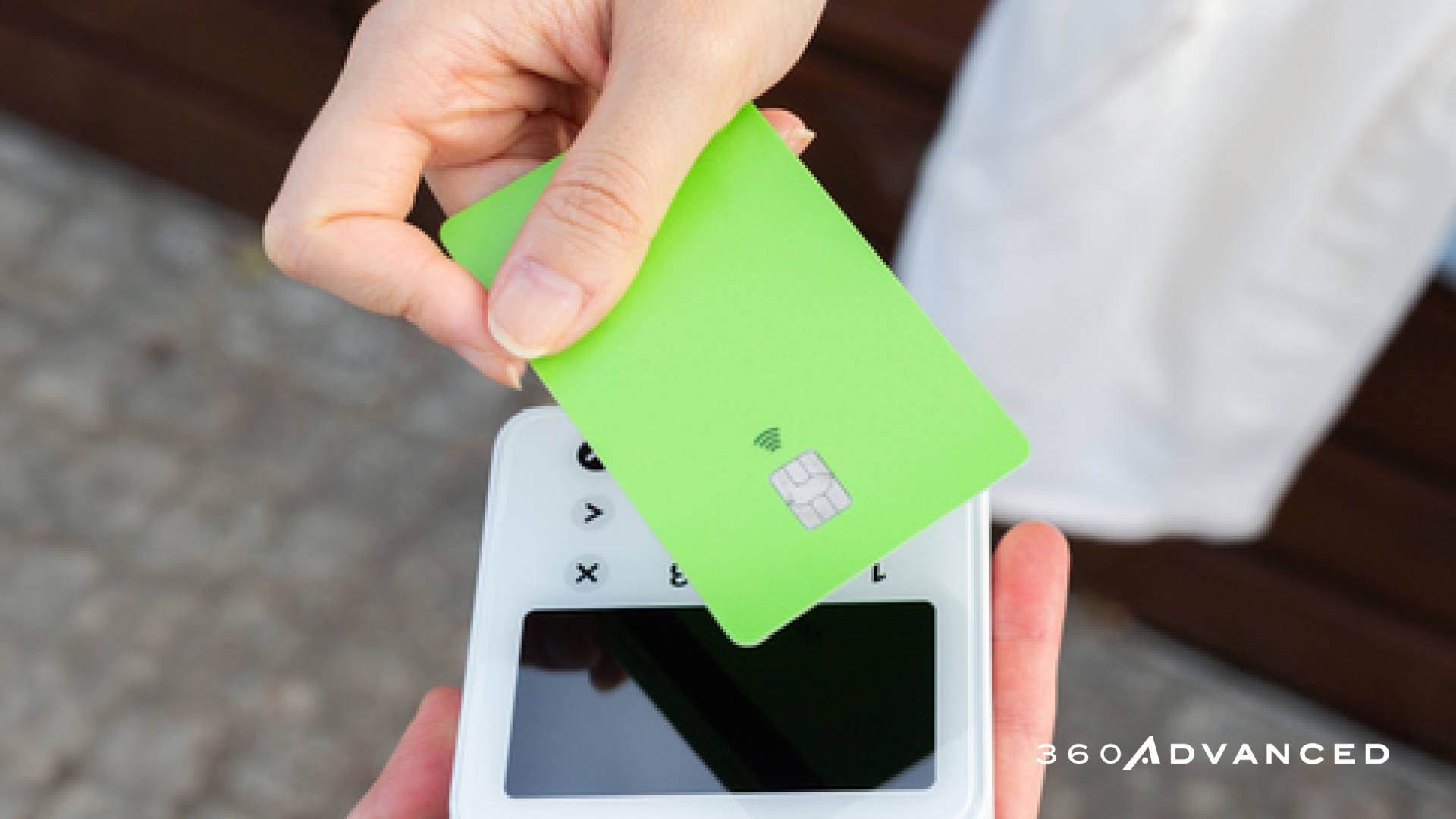 Person taps a bright green contactless card on a payment terminal, showcasing NFC payment.