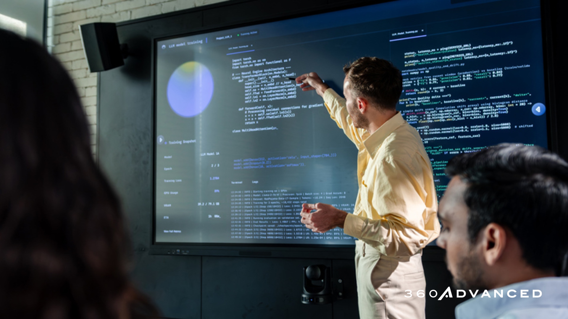 Software Developer Pointing at Source Code on a Shared Screen While Leading a Technical Review and Team Discussion in a Modern Office
